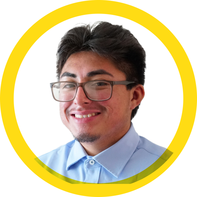 Edgar smiling, he wears glasses and a crisp blue collared shirt